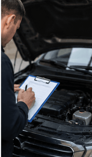 Vehicle inspection checklist being completed at an open bonnet